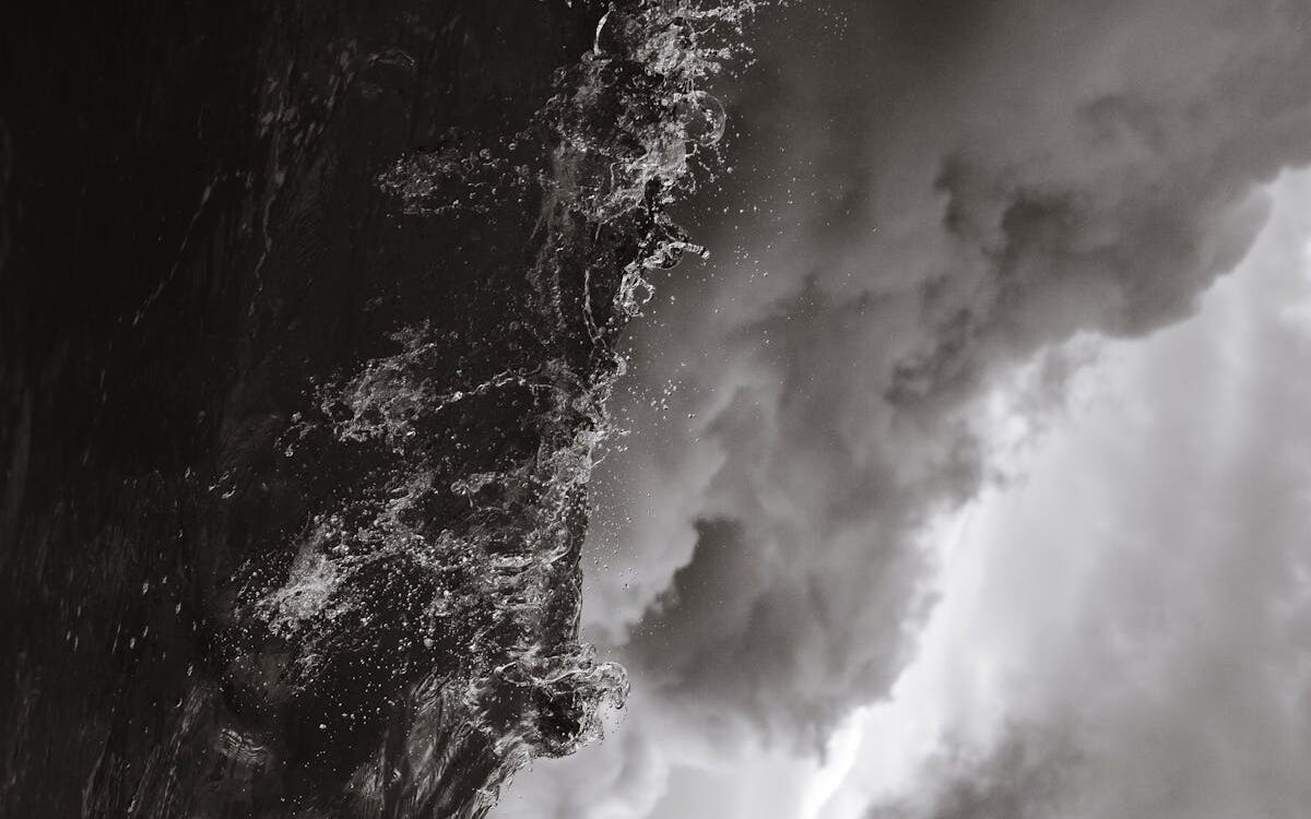 A dramatic black and white photo capturing stormy waves against dark clouds at Bondi Beach.