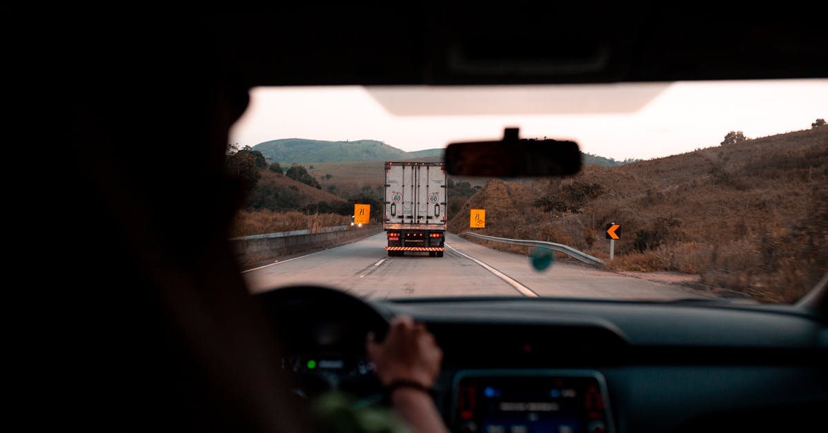 Scenic drive with a truck on a highway surrounded by hills. Perfect for travel themes.
